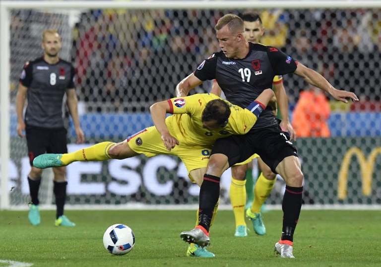 Căpitanul României, Vlad Chiricheș, în duel cu atacantul albanez Bekim Balaj, în timpul partidei disputate la Lyon, pe 19 iunie, în Grupa A a EURO 2016 / AFP PHOTO / PHILIPPE DESMAZES