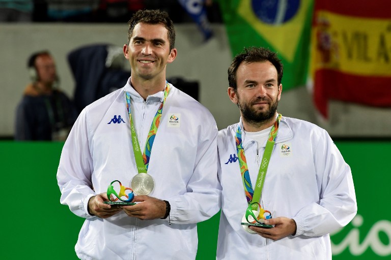 Silver medallists Romania's Florin Mergea (R) and Romania's Horia Tecau pose on the podium of the men's doubles final tennis match at the Olympic Tennis Centre of the Rio 2016 Olympic Games in Rio de Janeiro on August 12, 2016. / AFP PHOTO / JAVIER SORIANO